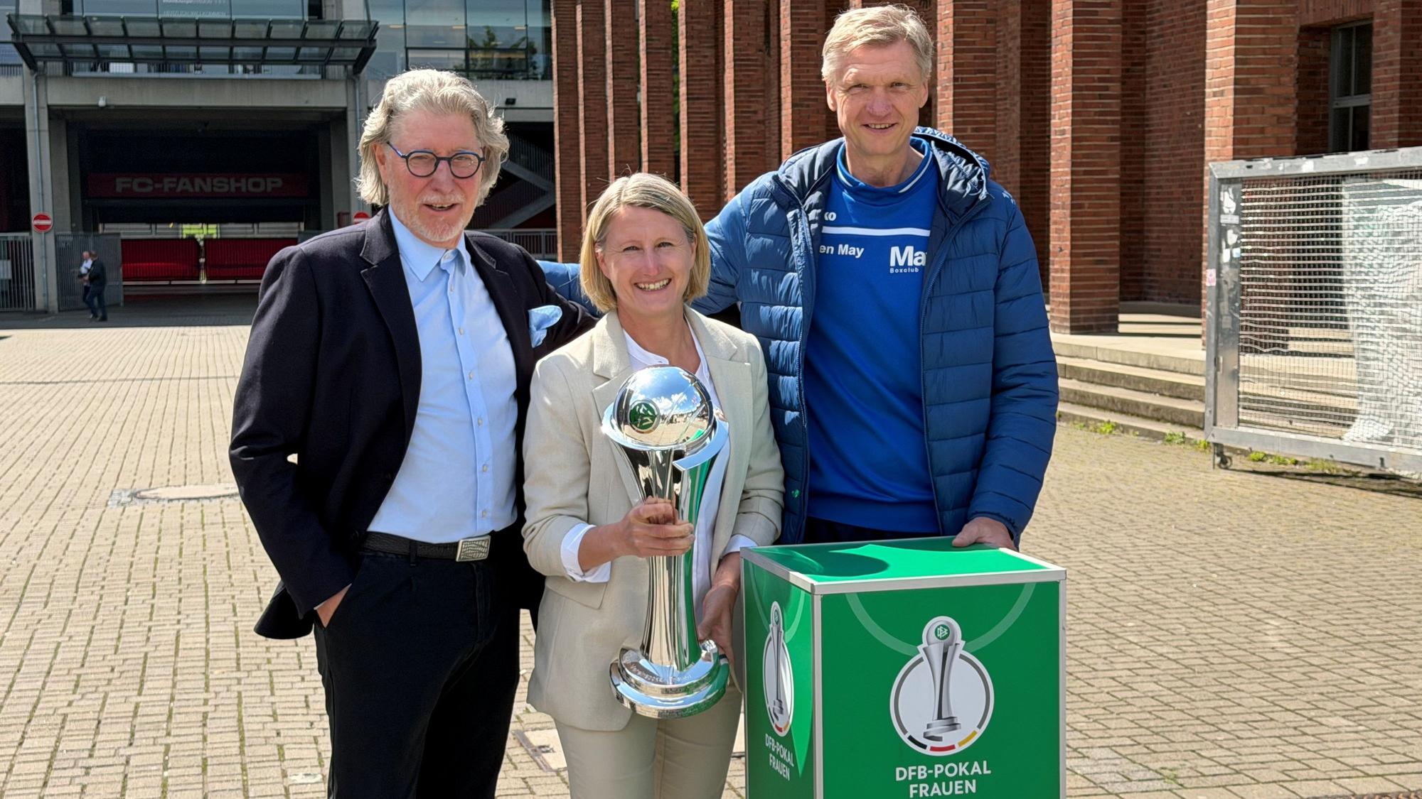 Toni Schumacher, Sonja Fuss und Torsten May präsentieren den Pokal.