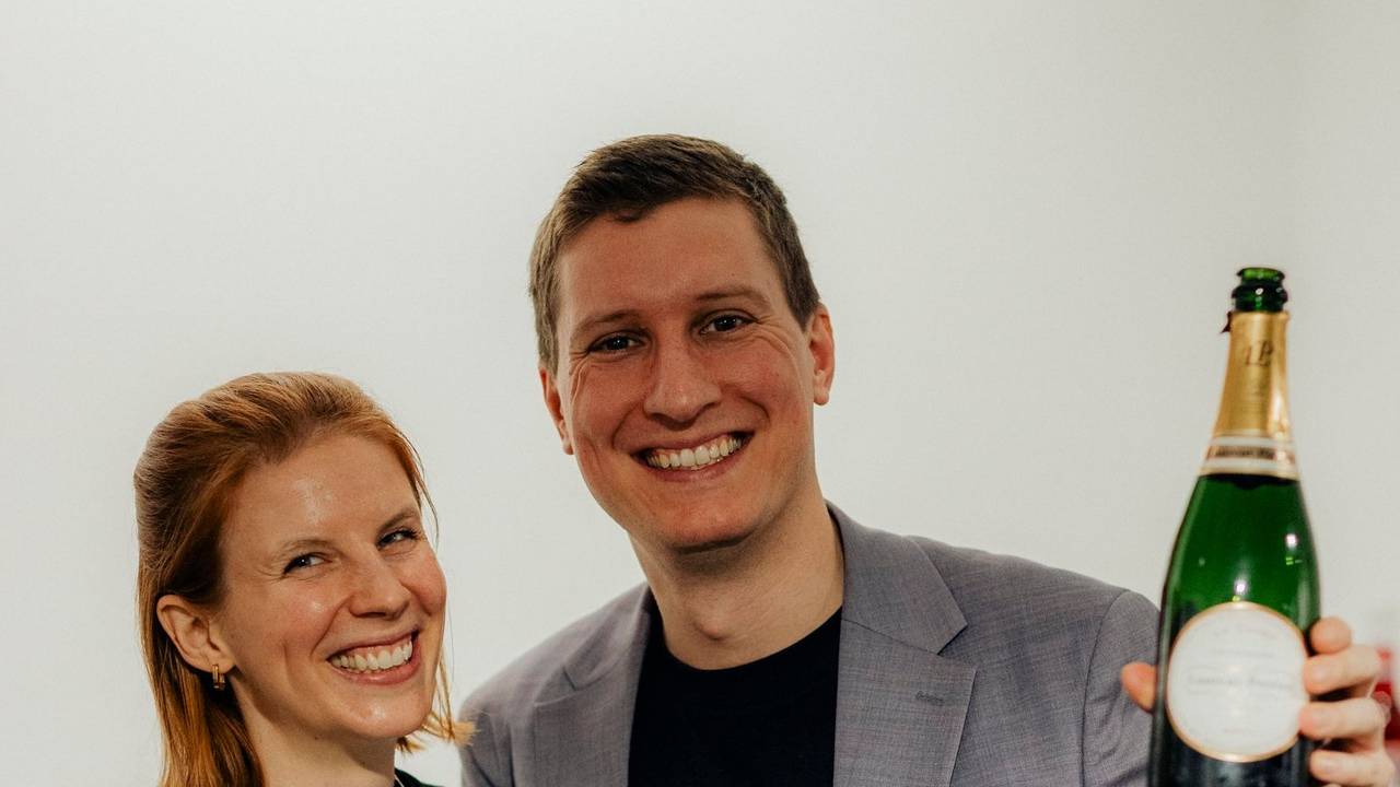 Timo und Katrin Brecht mit Sektflaschen in der Hand.