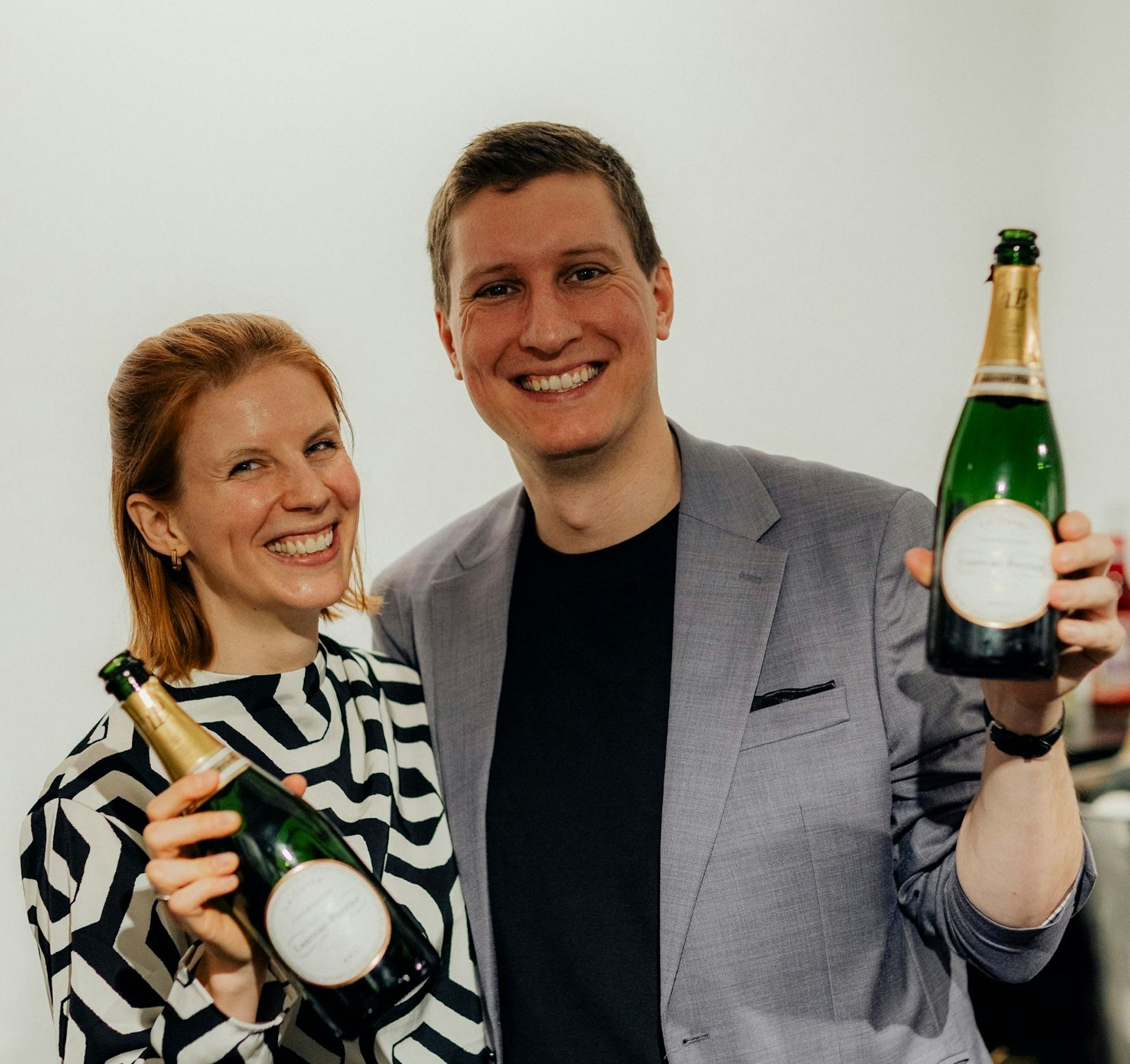 Timo und Katrin Brecht mit Sektflaschen in der Hand.