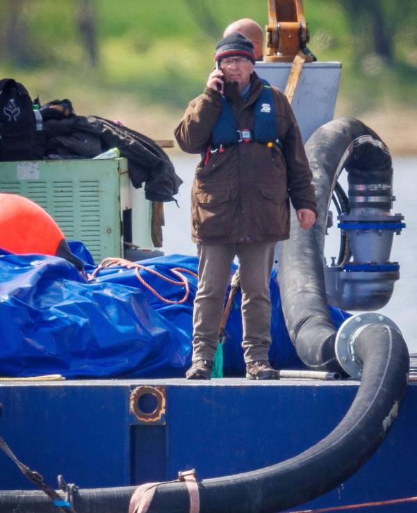 ill Backhaus (SPD), Umweltminister von Mecklenburg-Vorpommern, steht auf einer schwimmende Plattform und telefoniert, nachdem der gestrandete Buckelwal vor der Insel Poel mit Gurten in den Lastkahn gezogen wurde.