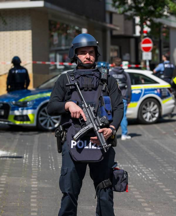 Schwerbewaffnete Polizeibeamte sichern den Bereich rund um eine Bankfiliale in Sinzig.