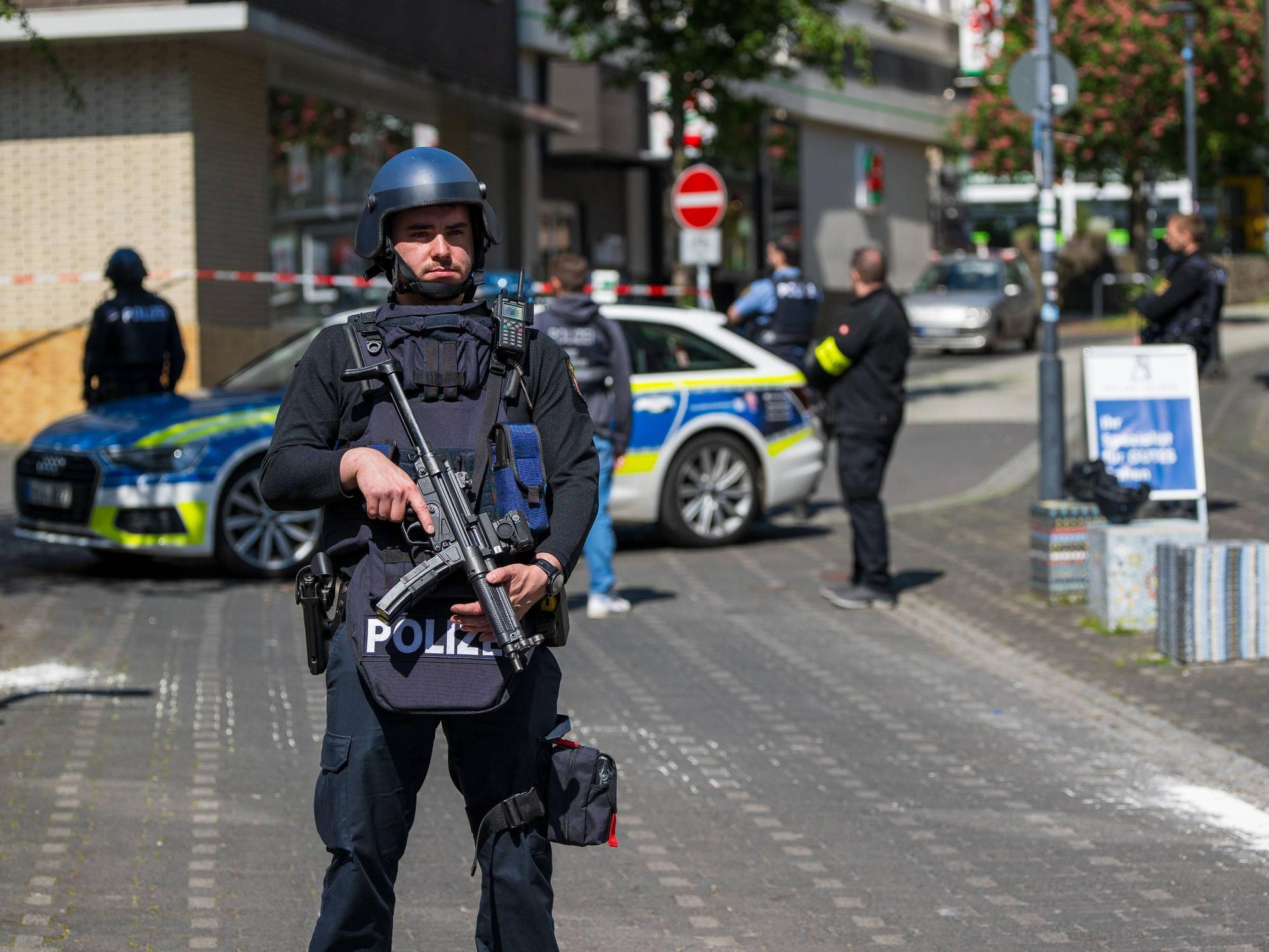 Schwerbewaffnete Polizeibeamte sichern den Bereich rund um eine Bankfiliale in Sinzig.