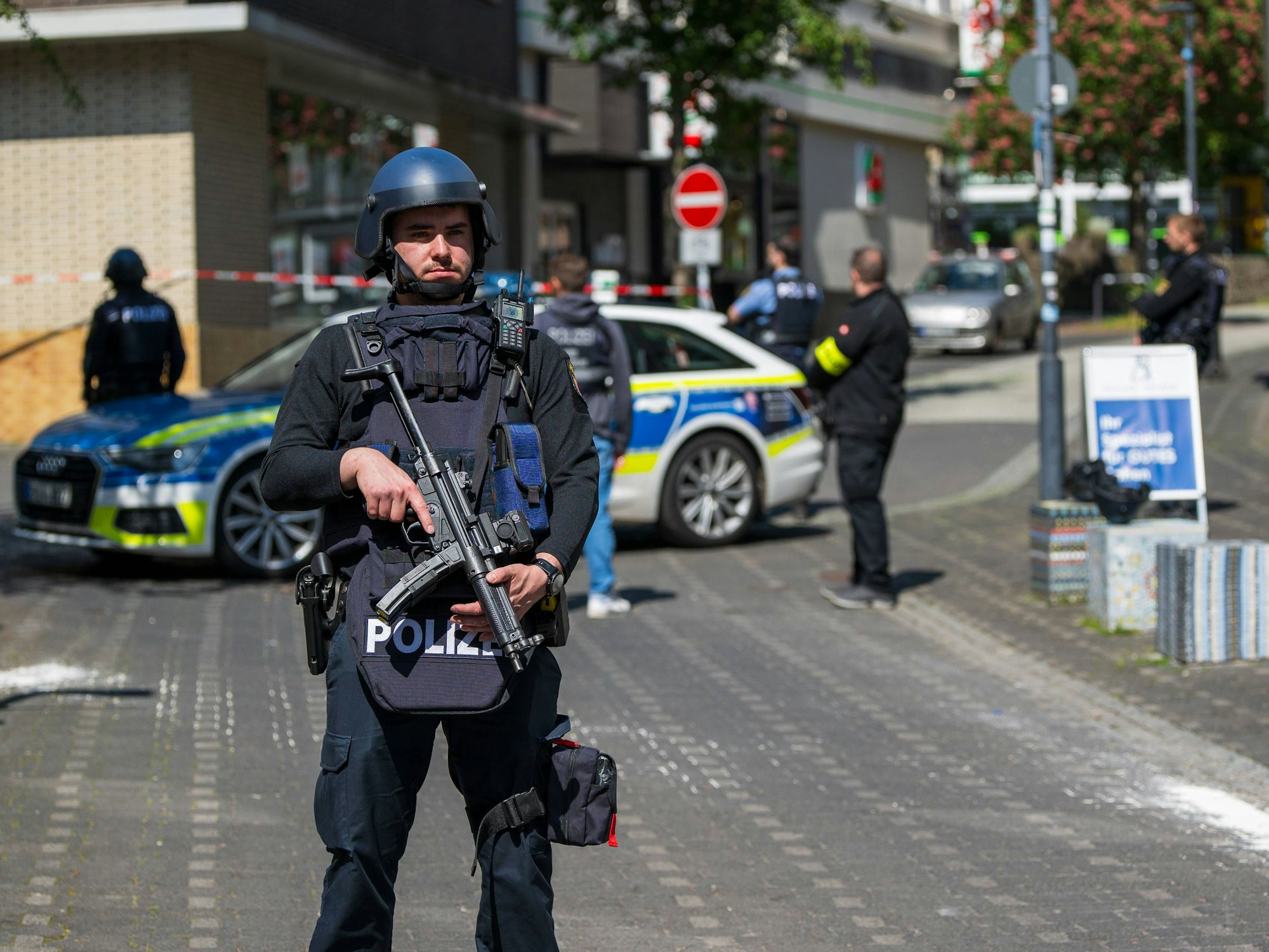Schwerbewaffnete Polizeibeamte sichern den Bereich rund um eine Bankfiliale in Sinzig.