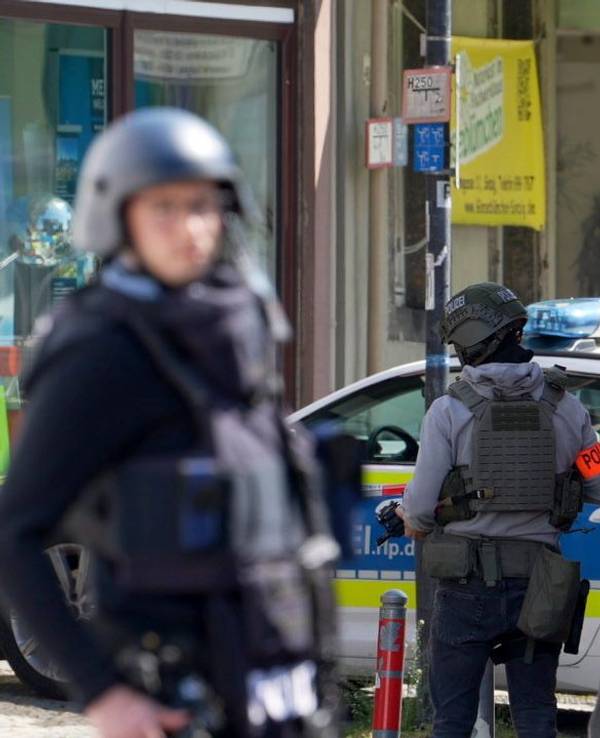 Polizisten stehen an einem Einsatzort. In einer Bankfiliale im rheinland-pfälzischen Sinzig ist es nach ersten Erkenntnissen der Polizei zu einer Geiselnahme gekommen.