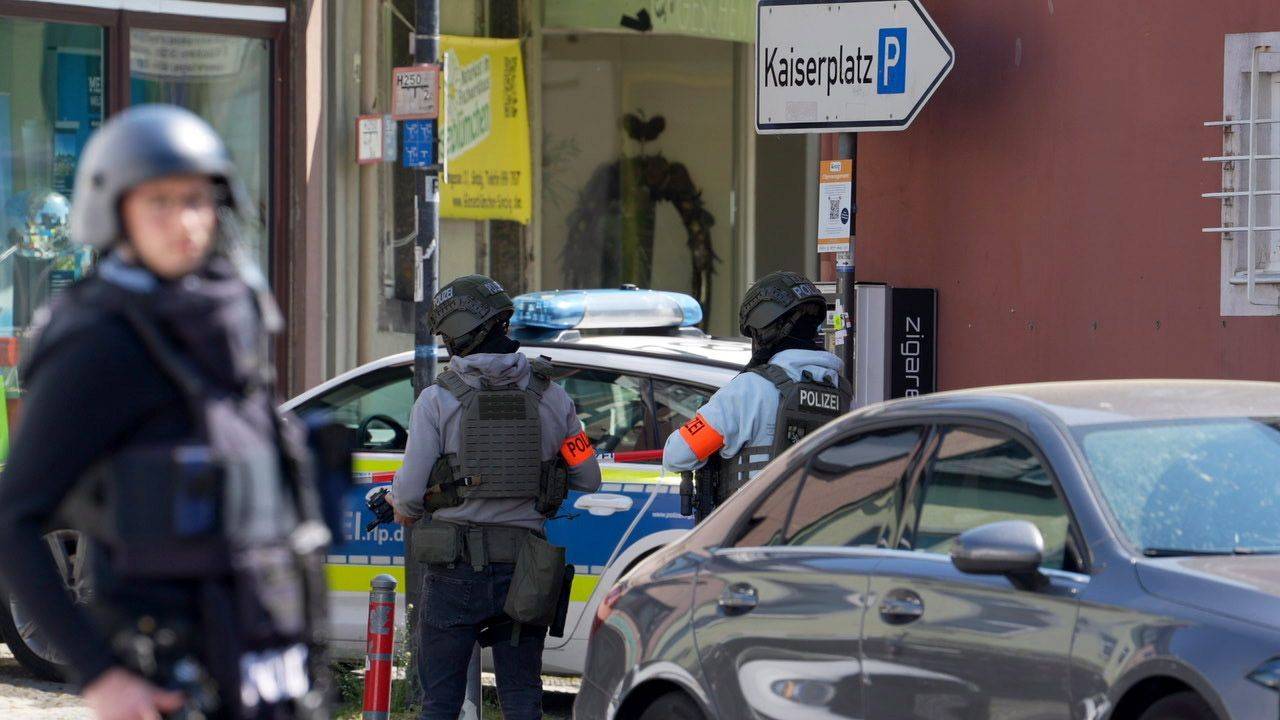 Polizisten stehen an einem Einsatzort. In einer Bankfiliale im rheinland-pfälzischen Sinzig ist es nach ersten Erkenntnissen der Polizei zu einer Geiselnahme gekommen.