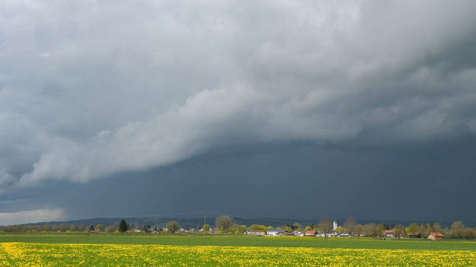 Gewitterwolken über Feldern und Häusern