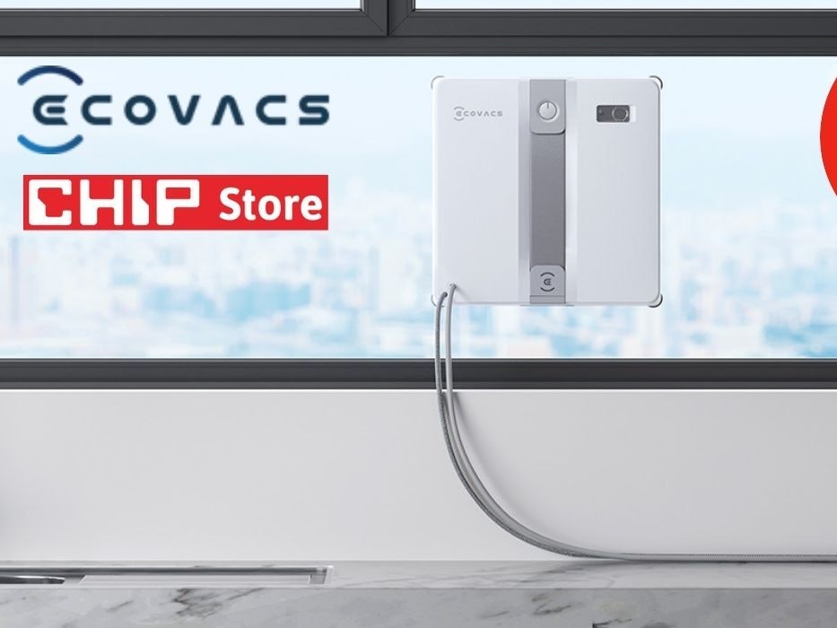 Der weiß-graue Ecovacs Winbot Mini Fensterputzroboter haftet an einem großen Küchenfenster mit Blick auf eine verschwommene Stadtsilhouette. Links oben das Ecovacs-Logo sowie das rote CHIP Store-Logo. Rechts oben roter Button mit der Aufschrift „Bestpreis -33 % Rabatt zur UVP".