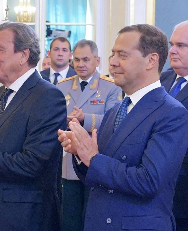 Wladimir Putin und der deutsche Ex-Bundeskanzler Gerhard Schröder schütteln im Mai 2018 Hände.