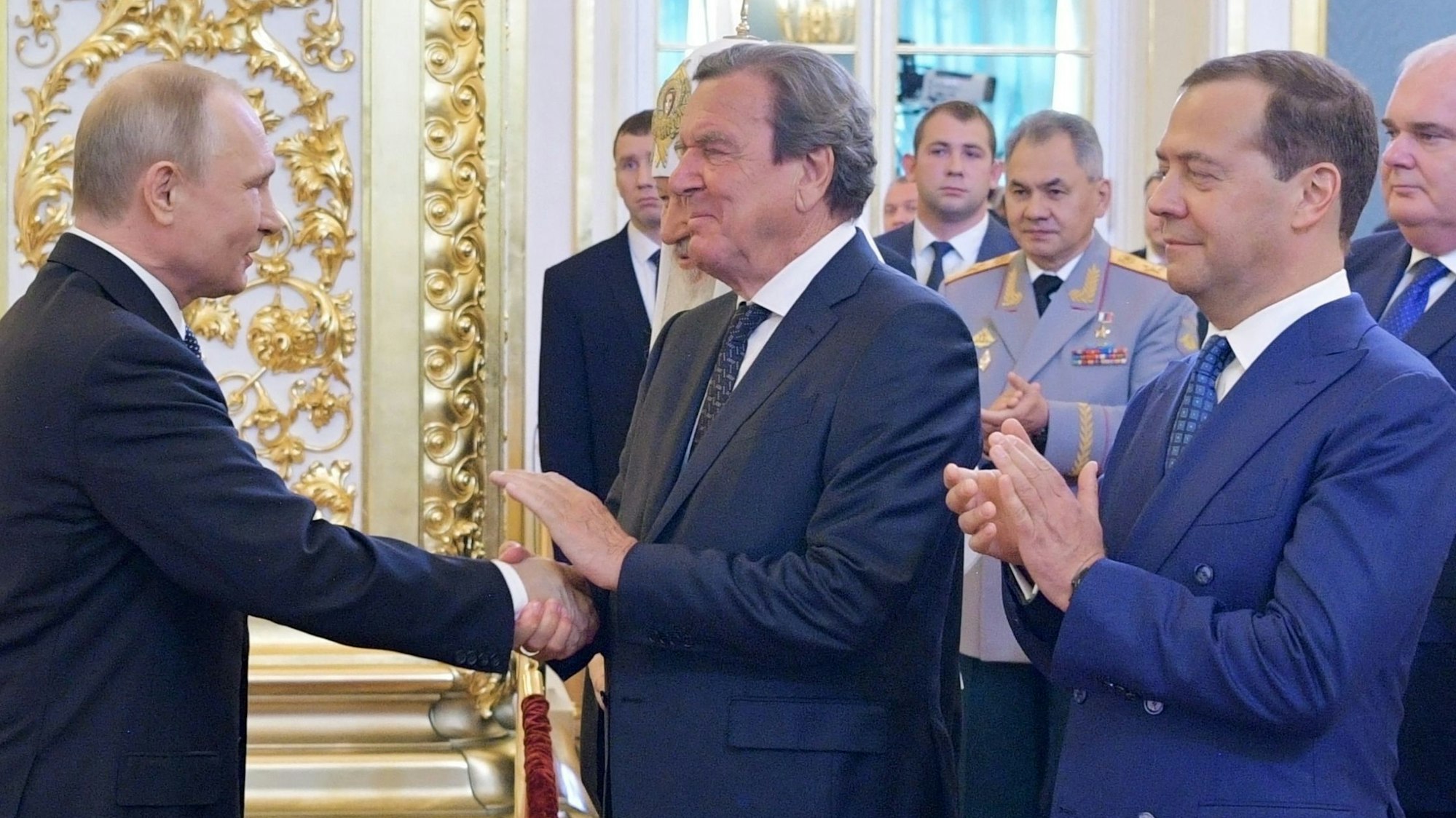 Wladimir Putin und der deutsche Ex-Bundeskanzler Gerhard Schröder schütteln im Mai 2018 Hände.