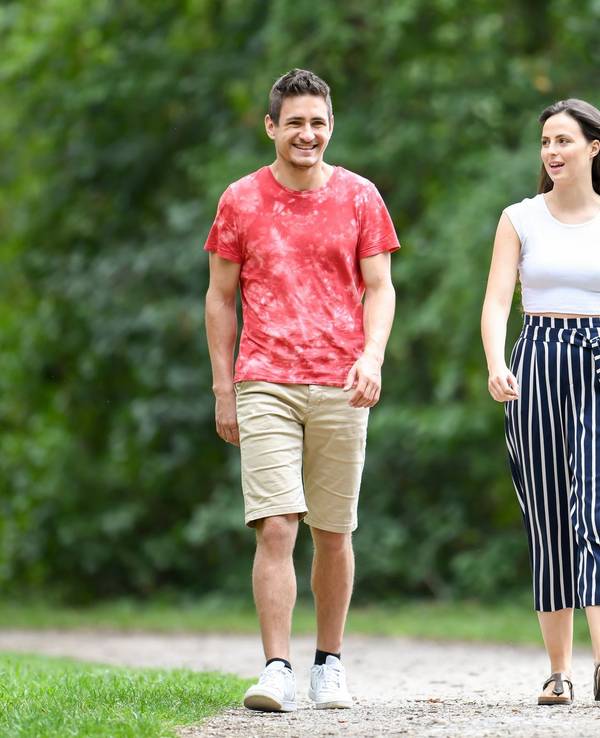 Mann und Frau gehen im Park spazieren