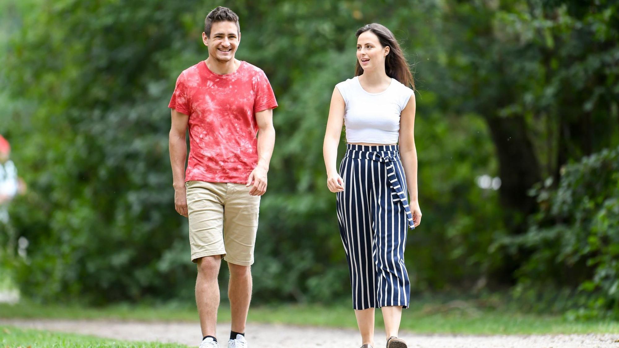 Mann und Frau gehen im Park spazieren