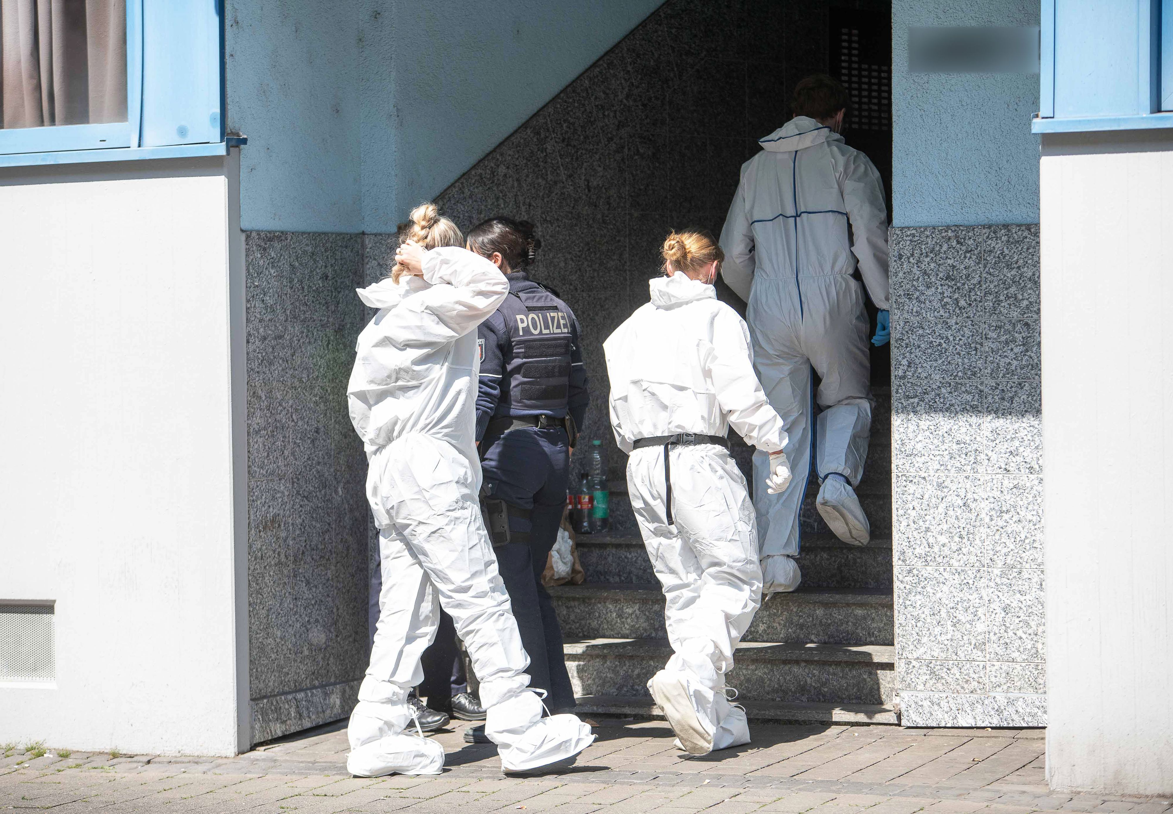 Beamte der Spurensicherung gehen in ein Mehrfamilienhaus.