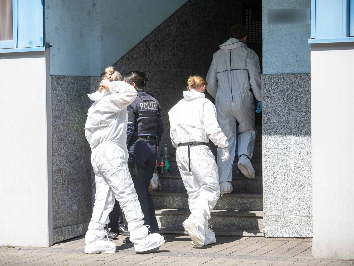 Beamte der Spurensicherung gehen in ein Mehrfamilienhaus.