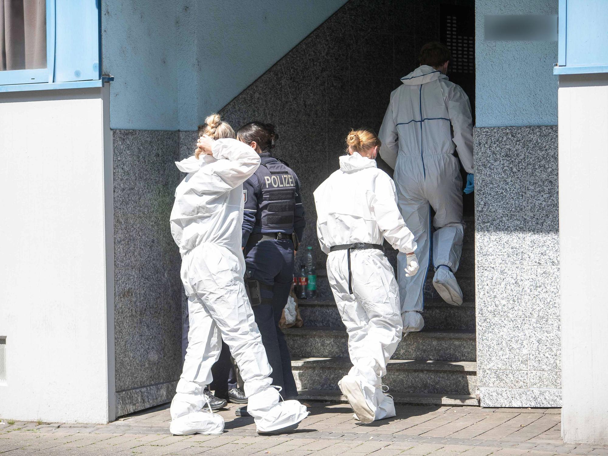 Beamte der Spurensicherung gehen in ein Mehrfamilienhaus.
