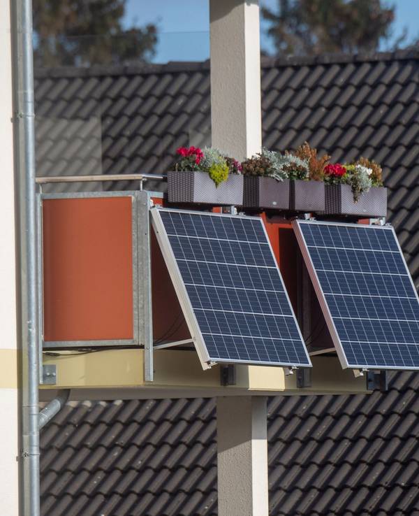 Solarmodule für ein Balkonkraftwerk hängen an einem Balkon