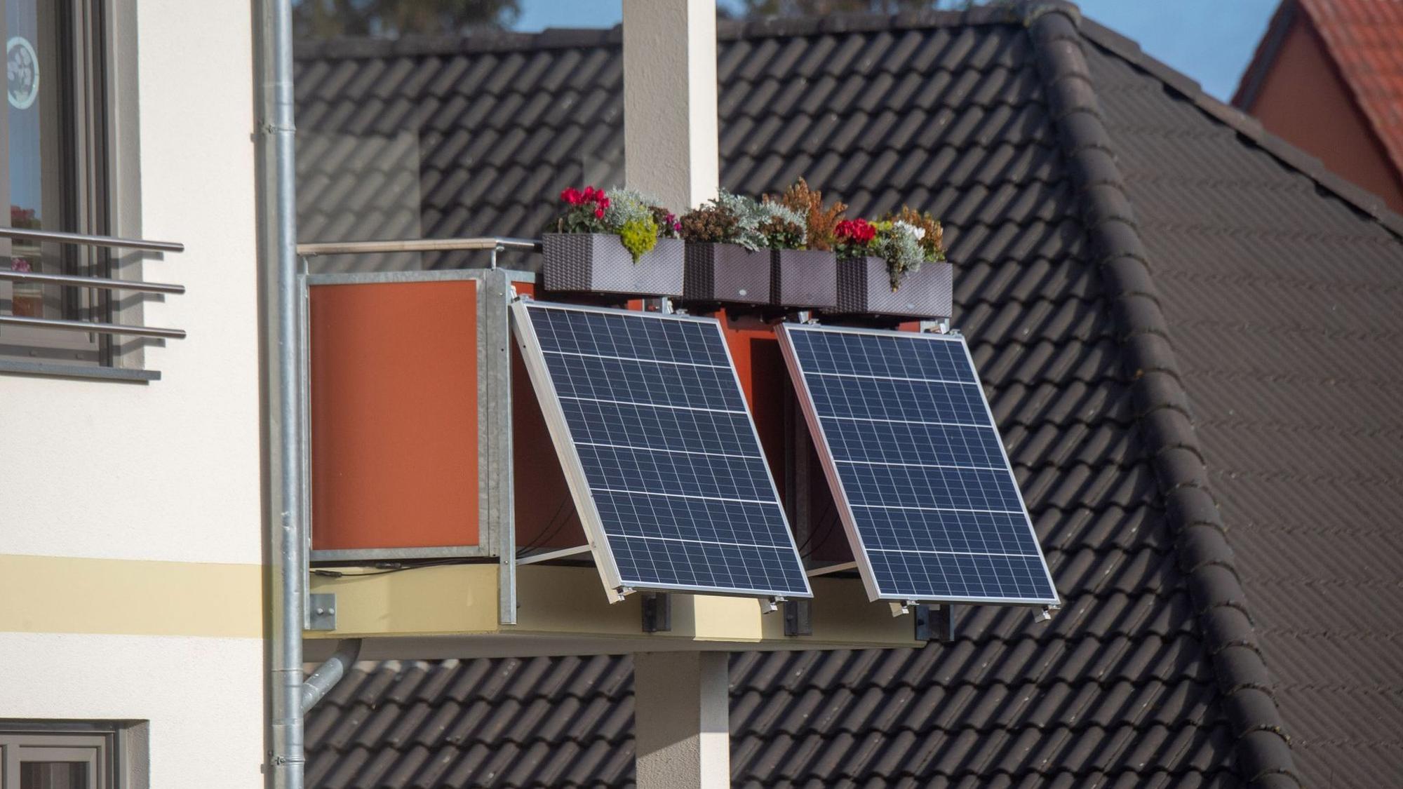 Solarmodule für ein Balkonkraftwerk hängen an einem Balkon