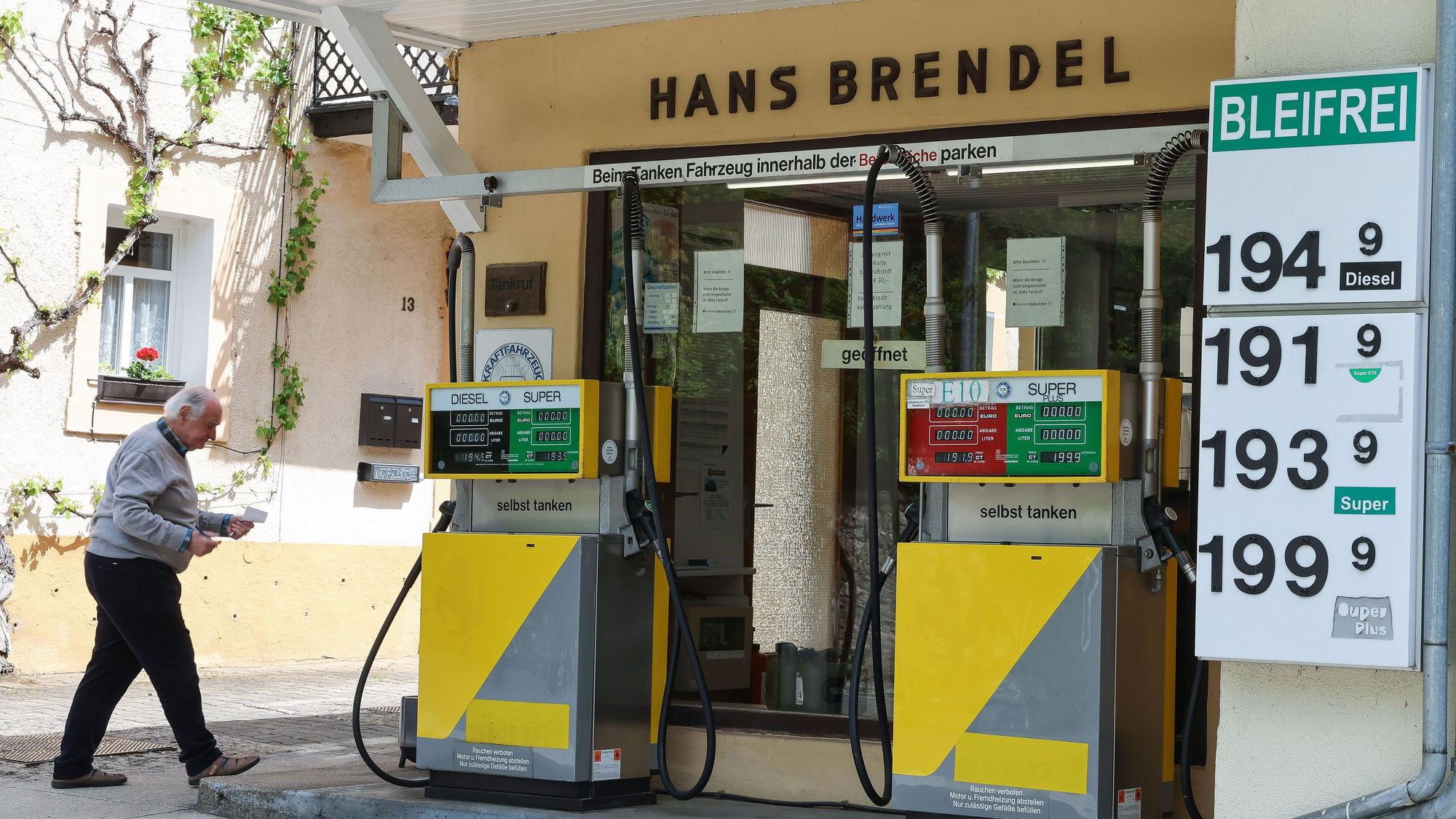 Herbert Brendel geht an seiner Tankstelle mit zwei Zapfsäulen, vier Zapfpistolen und vier Sorten Kraftstoff entlang.