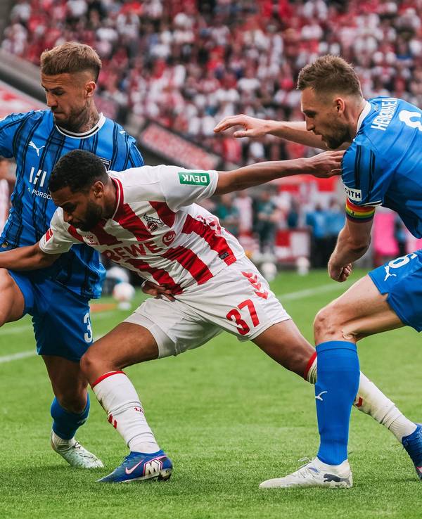 Zweikampf zwischen Linton Maina (Köln) und Niklas Dorsch sowie Patrick Mainka (Heidenheim).