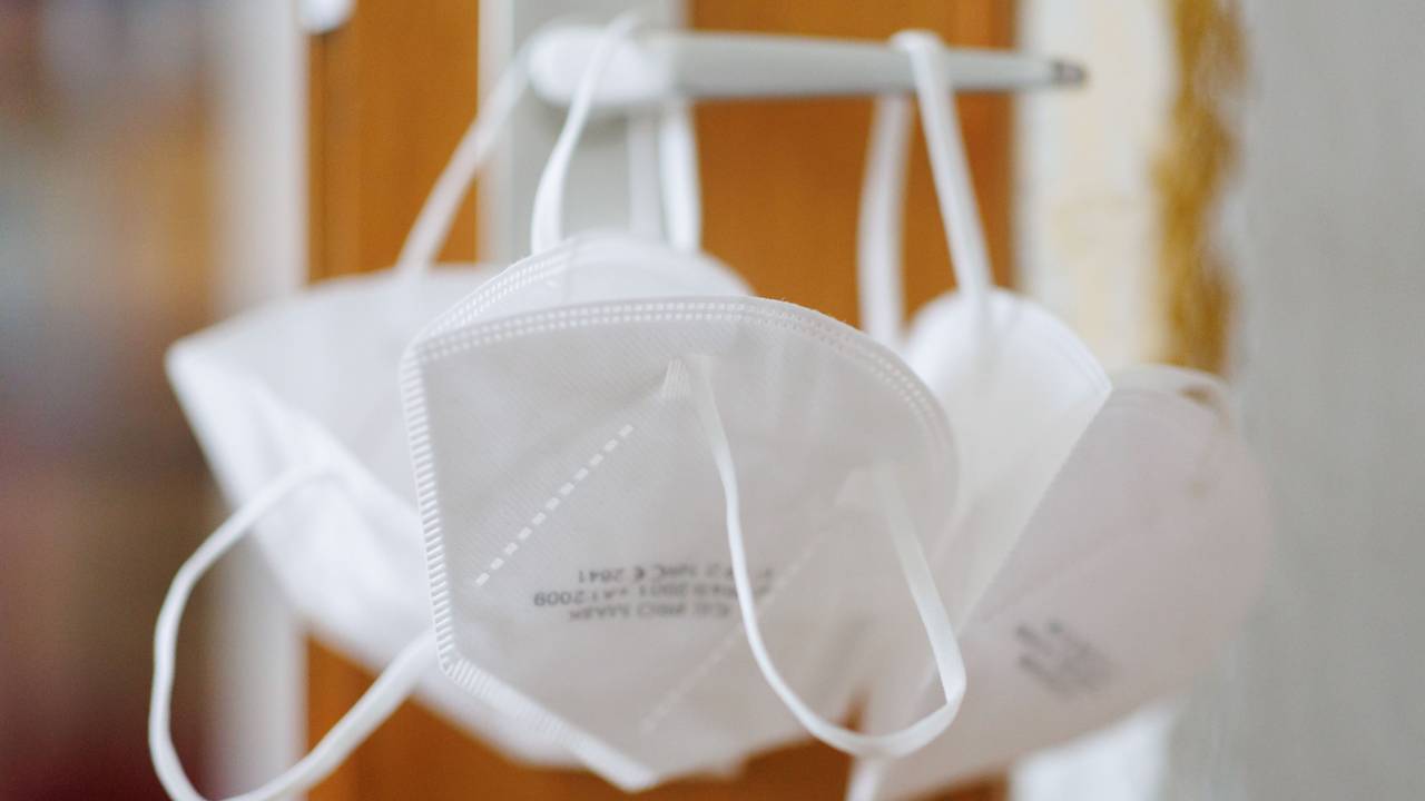 Ein 61-jähriger Geschäftsmann ist wegen gewerbsmäßigen Betrugs vom Kölner Landgericht verurteilt worden. Das Symbolfoto zeigt FFP2-Masken an einer Türklinke.
