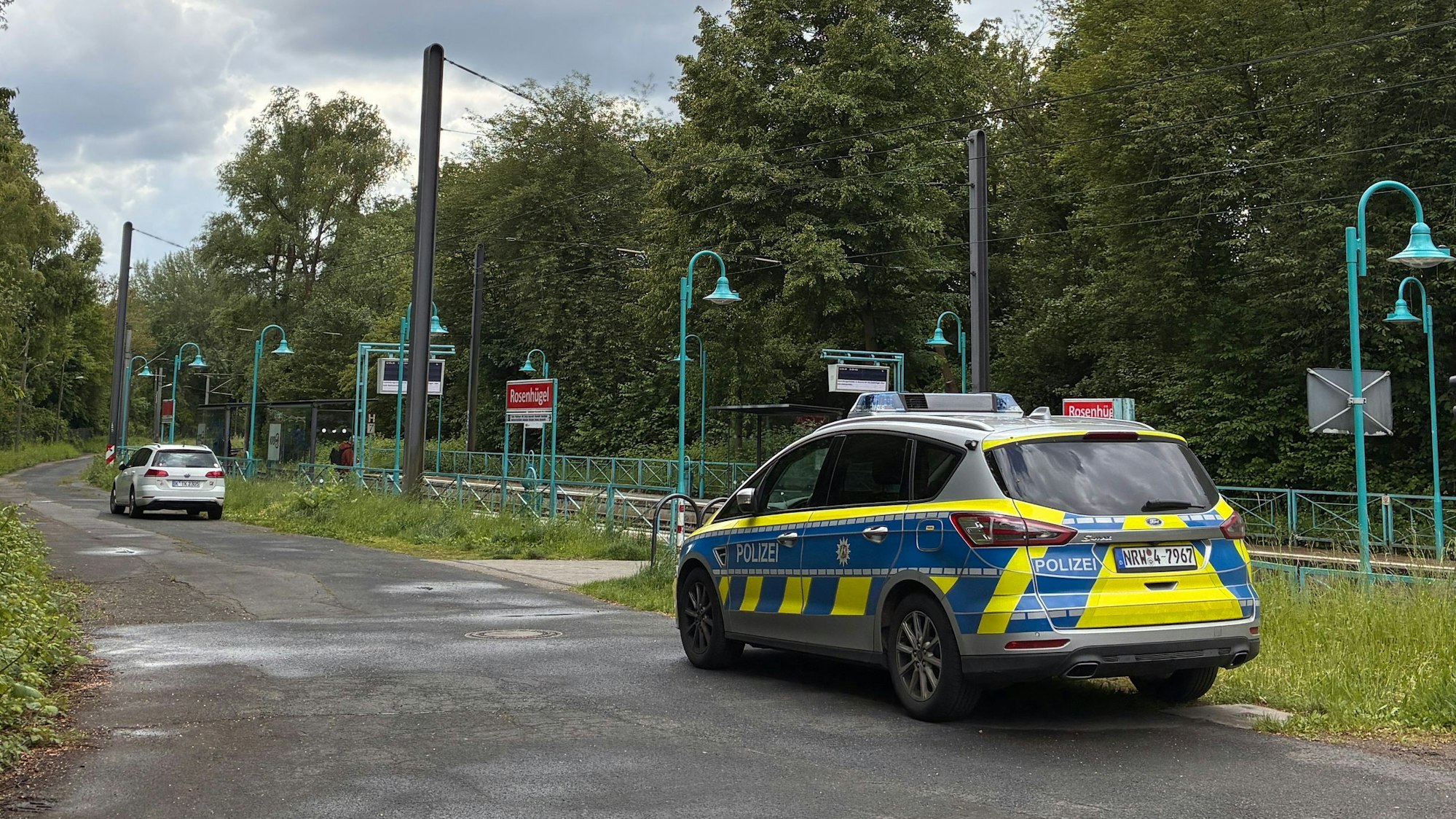 Ein Streifenwagen steht an Bahngleisen.