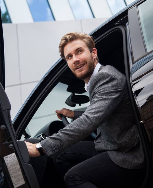 Ein Mann sitzt im Auto bei geöffneter Tür