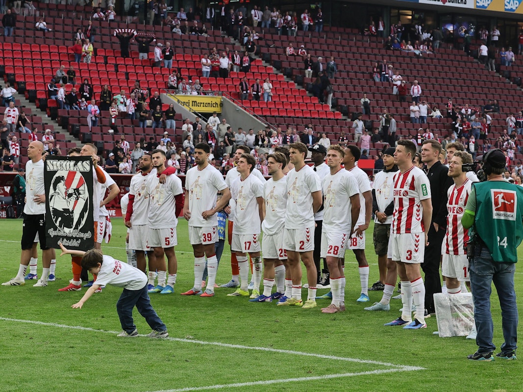 Die Mannschaft des 1. FC Köln steht vor ihren Fans.