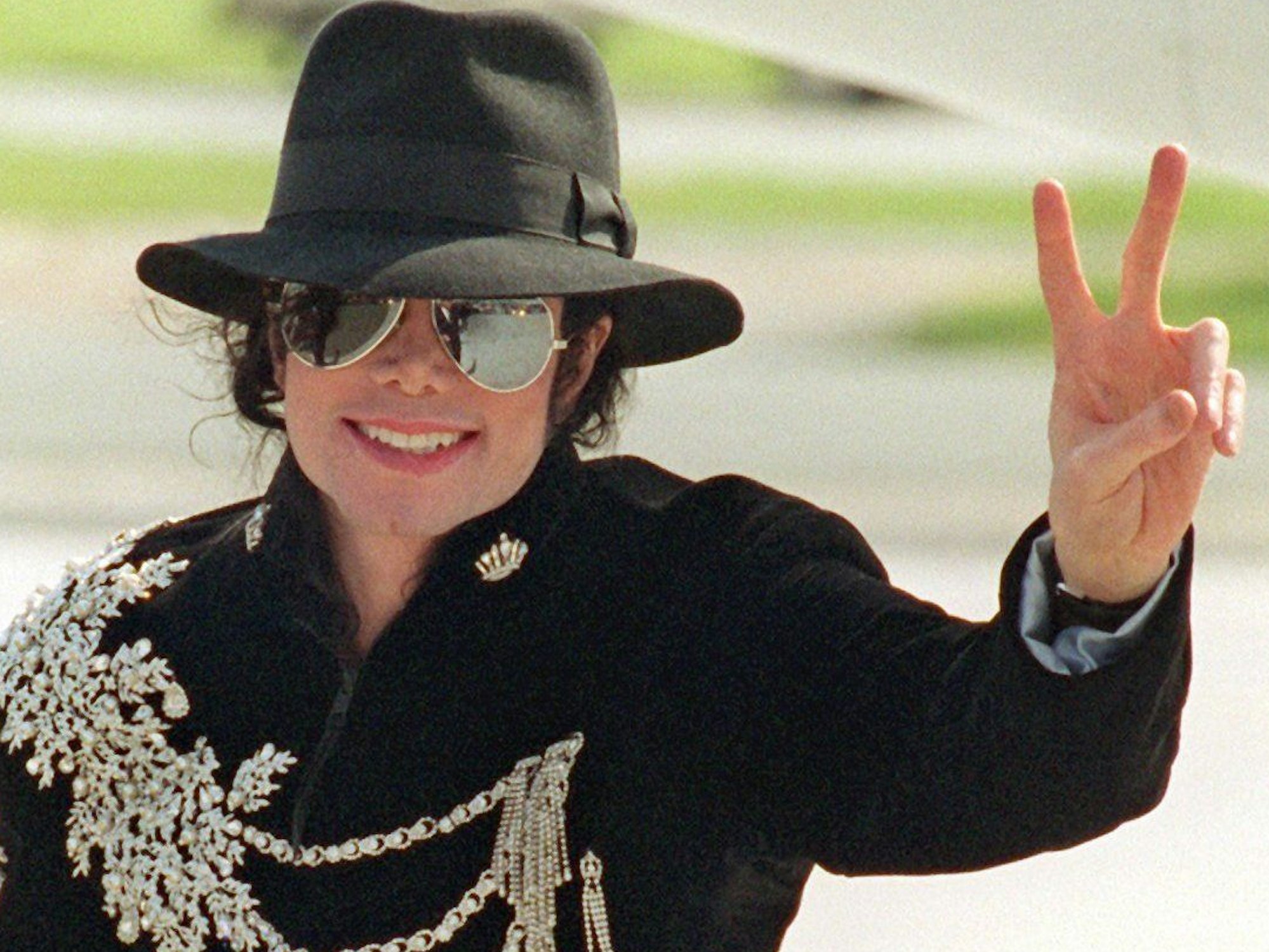 Megastar Michael Jackson lächelt und zeigt das Victory-Zeichen bei seiner Ankunft in Bremen.