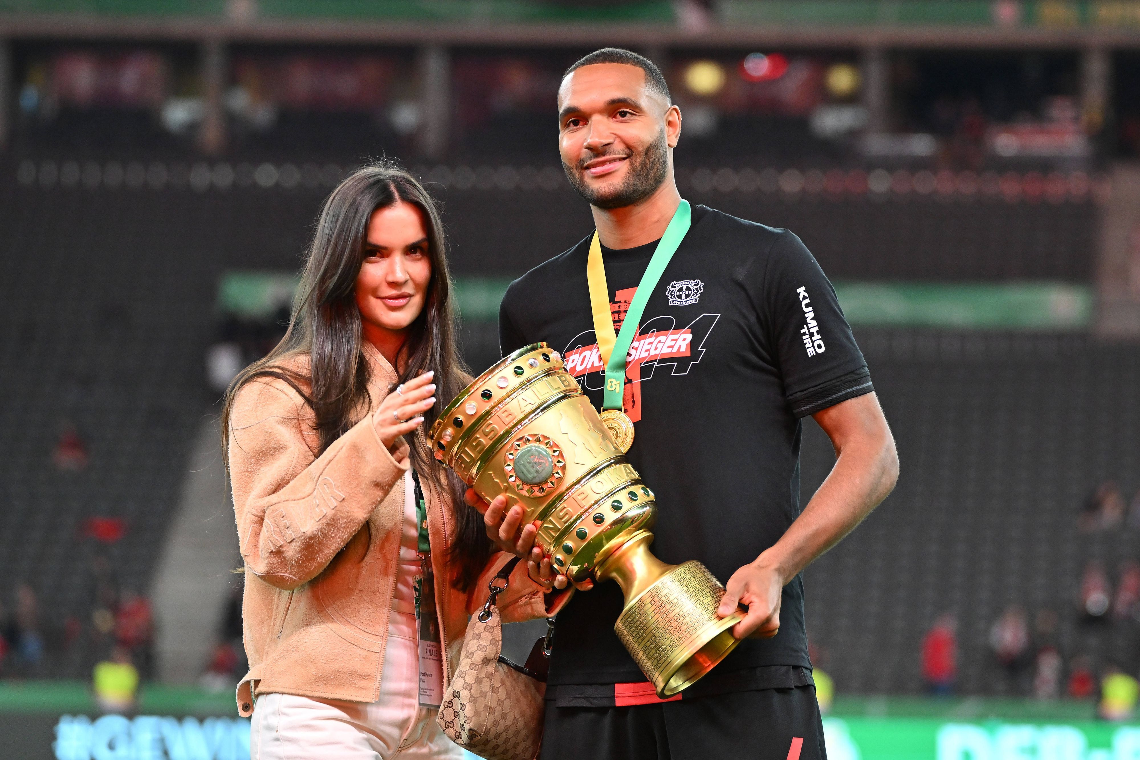 Jonathan Tah und seine Partnerin Luisa mit der DFB-Pokal-Trophäe.