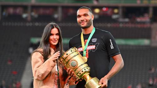 Jonathan Tah und seine Partnerin Luisa mit der DFB-Pokal-Trophäe.