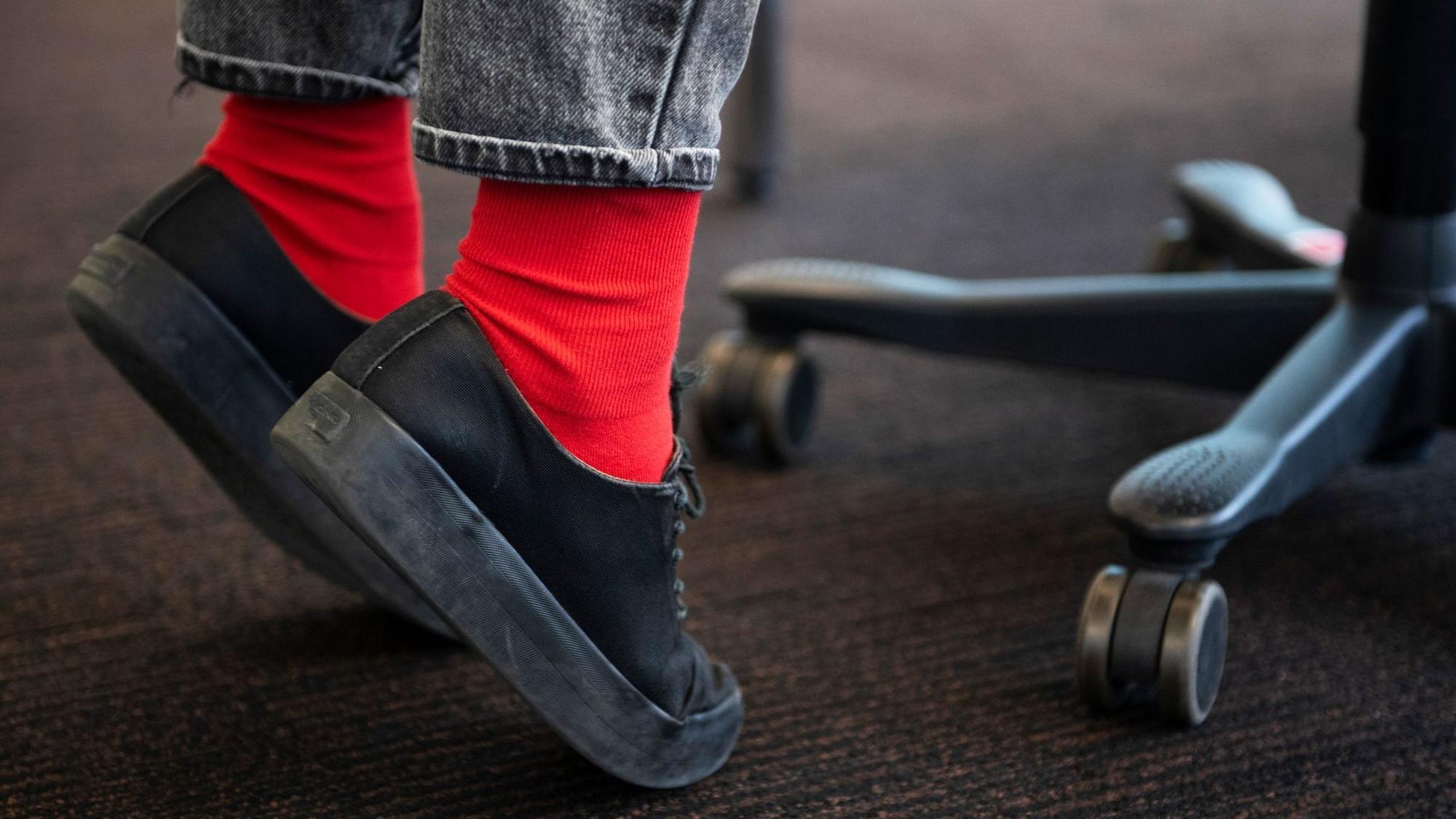 Person macht Zehenstand im Büro