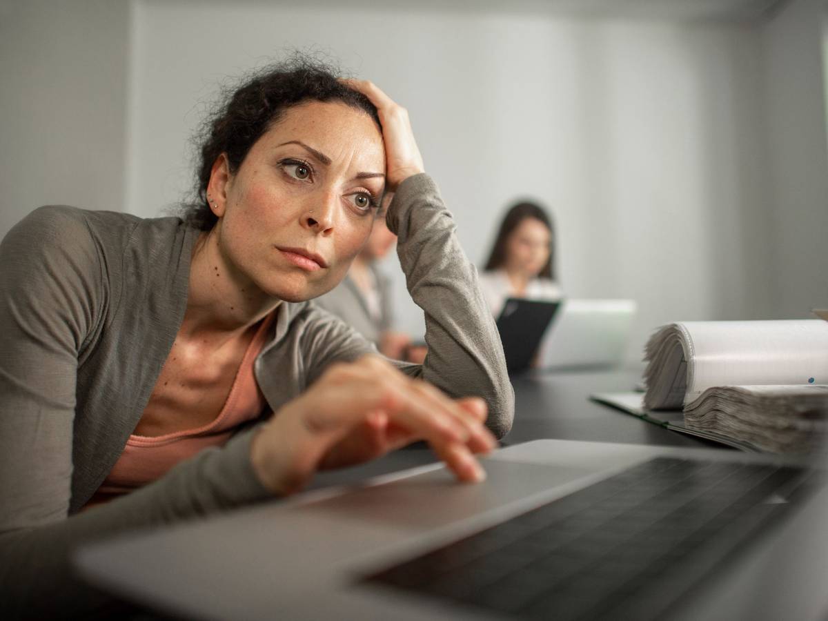 Frau sitzt frustriert vor einem Laptop