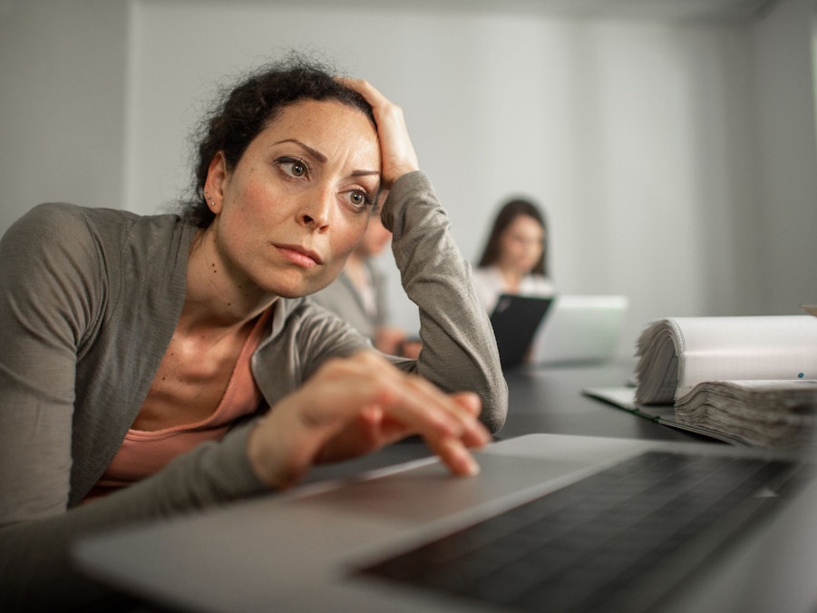 Frau sitzt frustriert vor einem Laptop