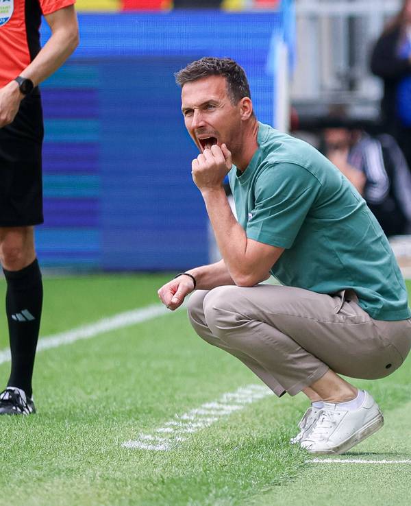 Christian Eichner, Trainer des Karlsruher SC, hockt am Spielfeldrand.