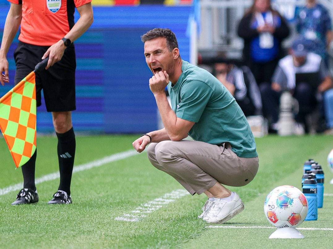 Christian Eichner, Trainer des Karlsruher SC, hockt am Spielfeldrand.