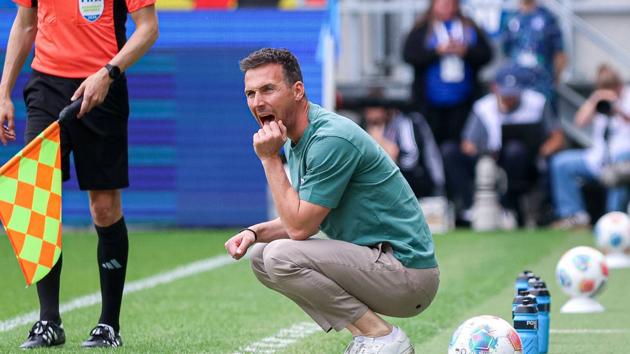 Christian Eichner, Trainer des Karlsruher SC, hockt am Spielfeldrand.