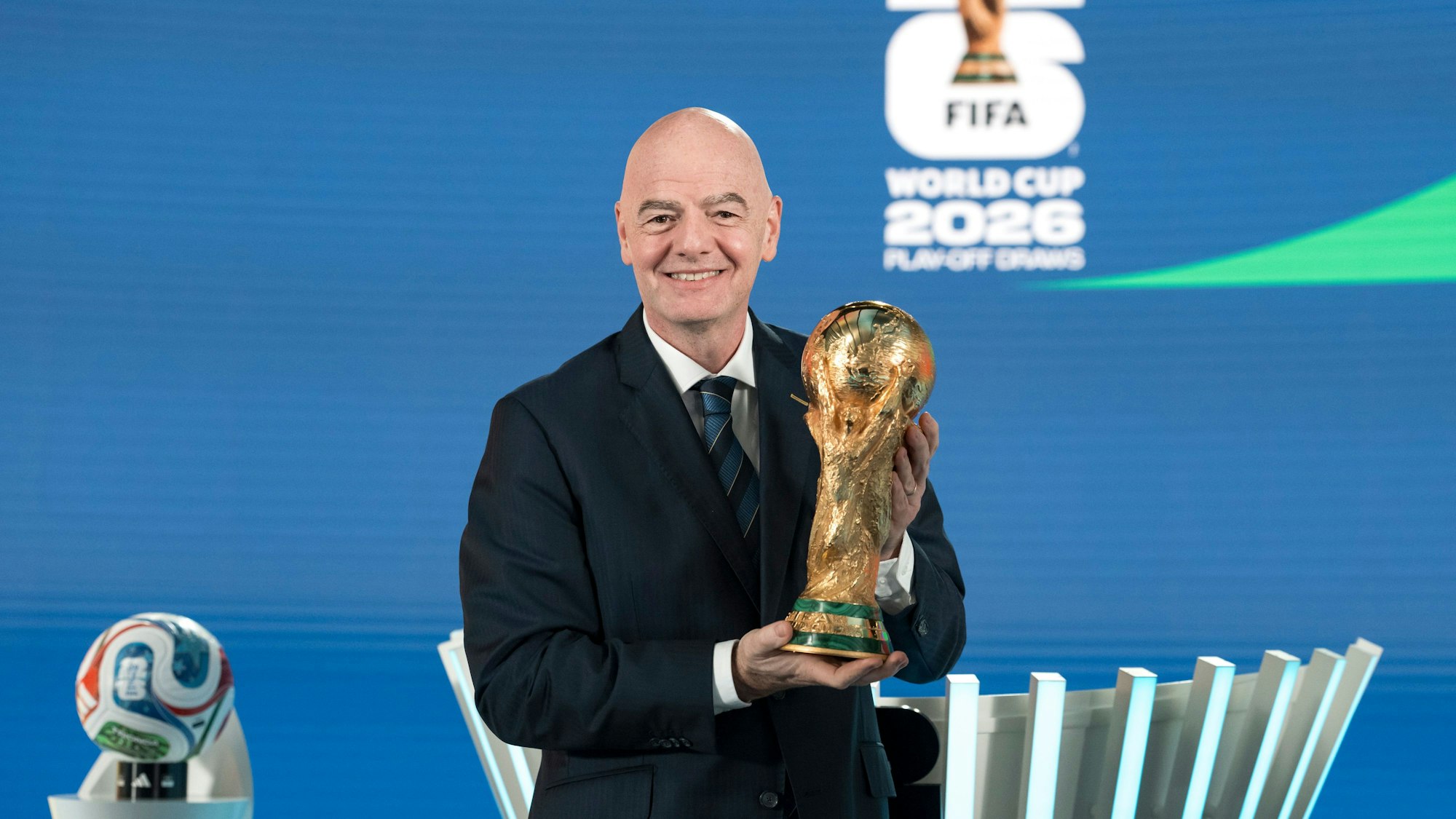 Gianni Infantino, FIFA-Präsident, hält während der Auslosung der Playoffs für die FIFA‑Fußball-Weltmeisterschaft 2026 den WM-Pokal.