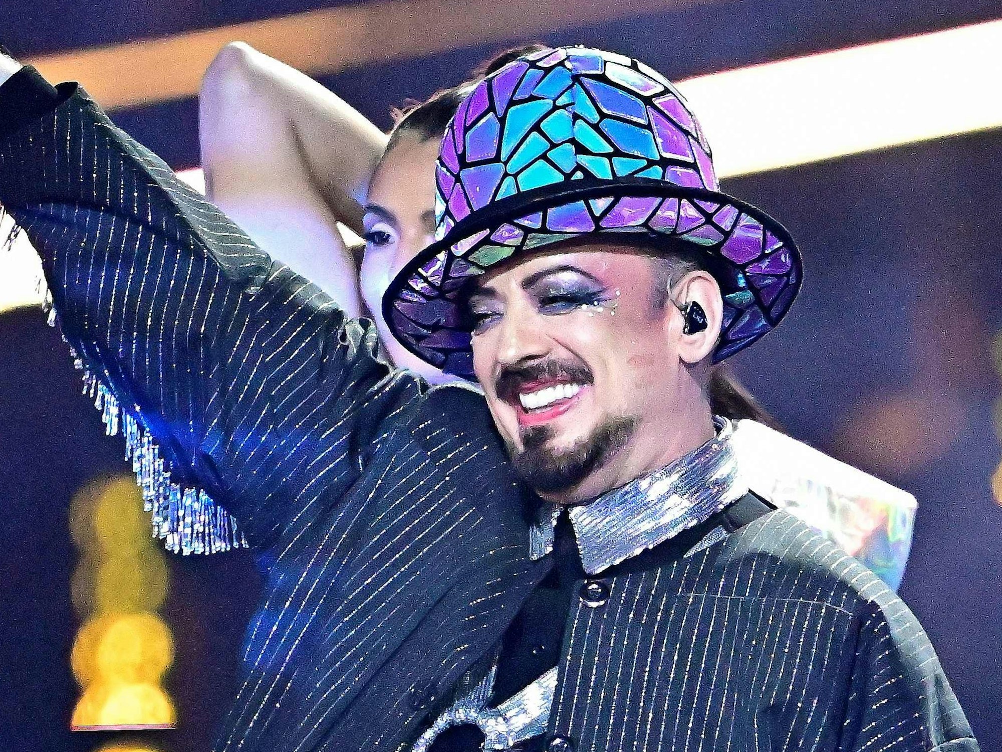 Boy George winkt.