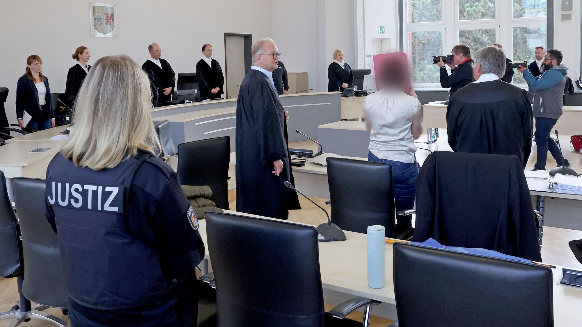 Eine Justizmitarbeiterin (l-r), Thomas Löcker, Anwalt, die Angeklagte und Andreas Ohm, Anwalt, stehen im Saal des Landgerichts zu Beginn der Fortsetzung des Mordprozesses.