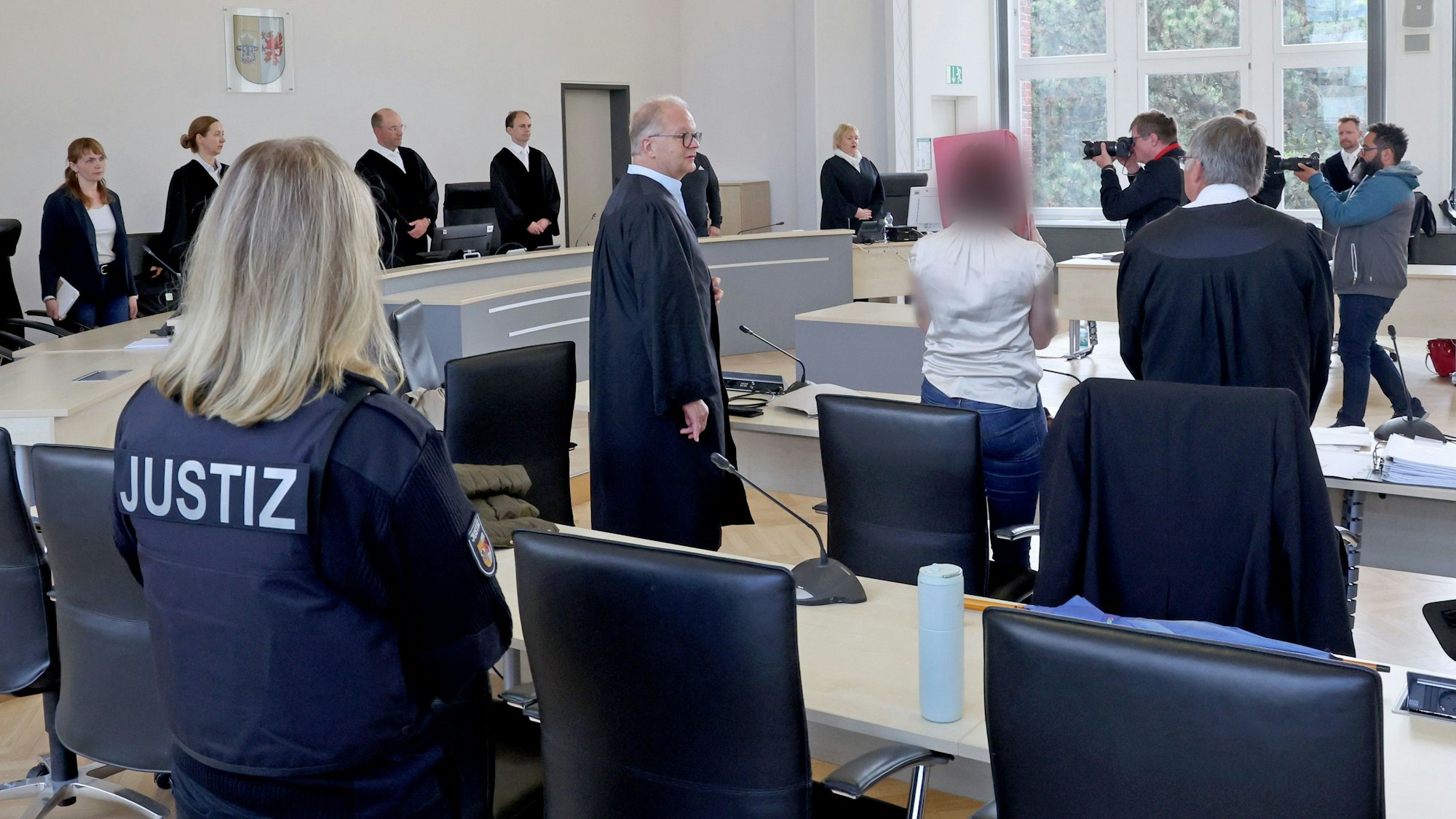 Eine Justizmitarbeiterin (l-r), Thomas Löcker, Anwalt, die Angeklagte und Andreas Ohm, Anwalt, stehen im Saal des Landgerichts zu Beginn der Fortsetzung des Mordprozesses.