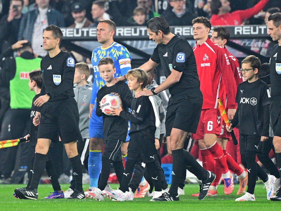 Die Mannschaft des 1. FC Köln kommt angeführt von Deniz Aytekin auf den Platz.