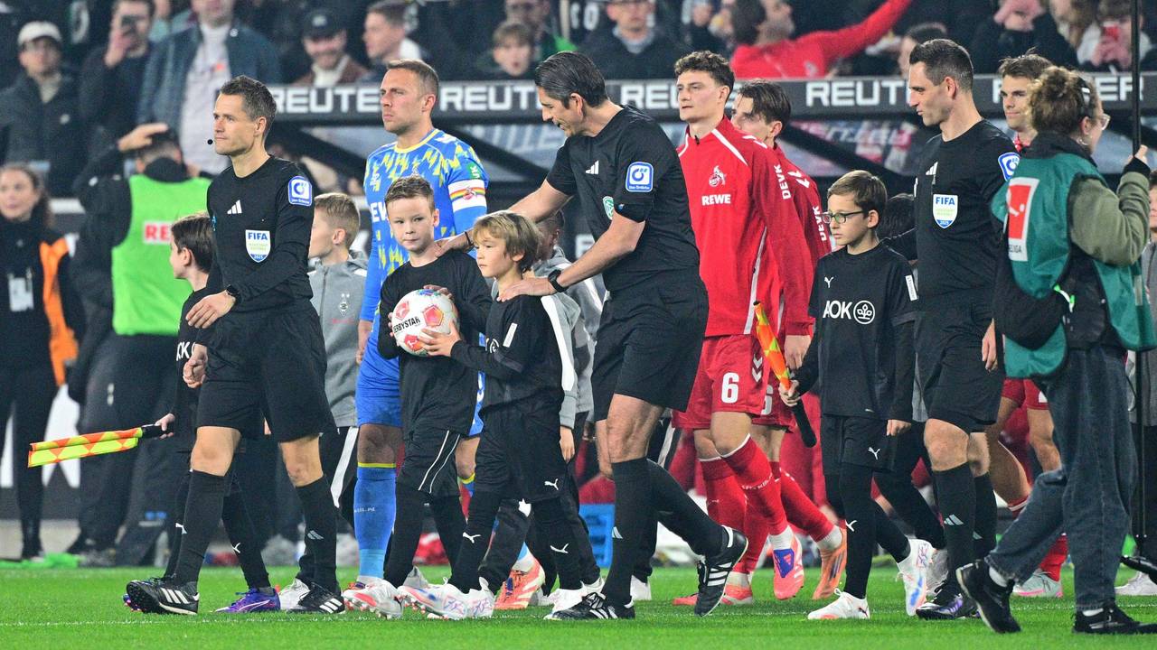Die Mannschaft des 1. FC Köln kommt angeführt von Deniz Aytekin auf den Platz.