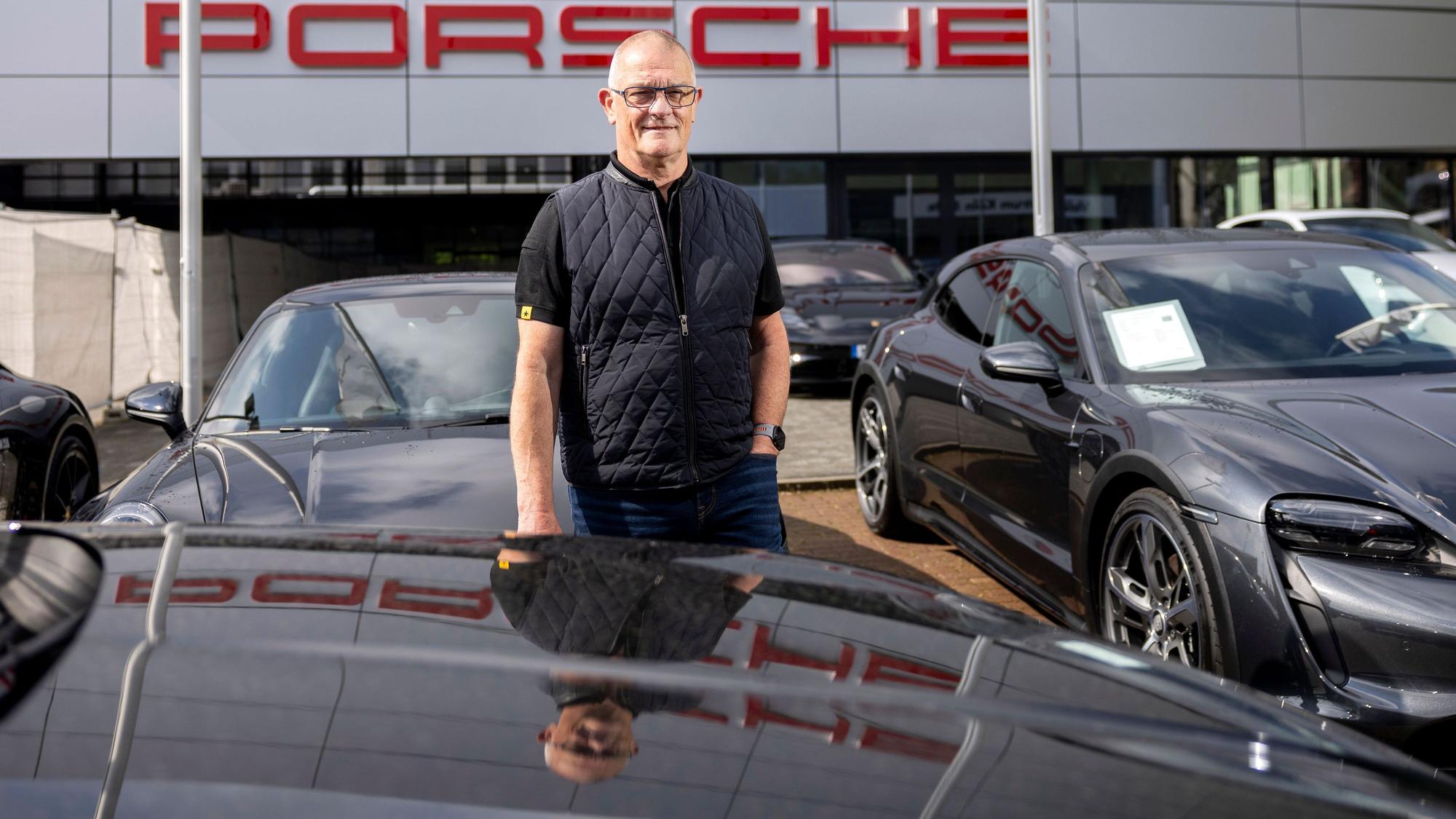 Jürgen Schillmeier, seit wenigen Tagen Rentner, steht zwischen den glänzenden Sportwagen. Insgesamt war der gelernte Mechaniker 47,67 Jahre für Porsche tätig.