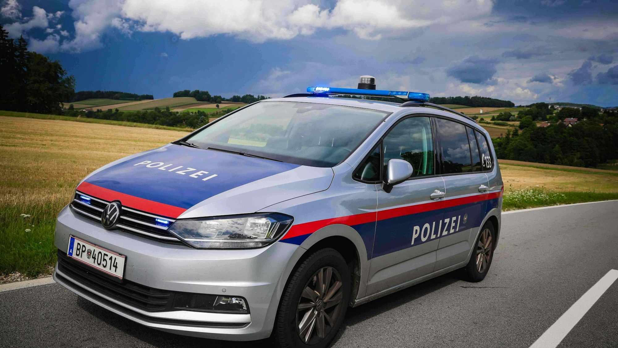 Polizeiauto mit Blaulicht auf Landstraße