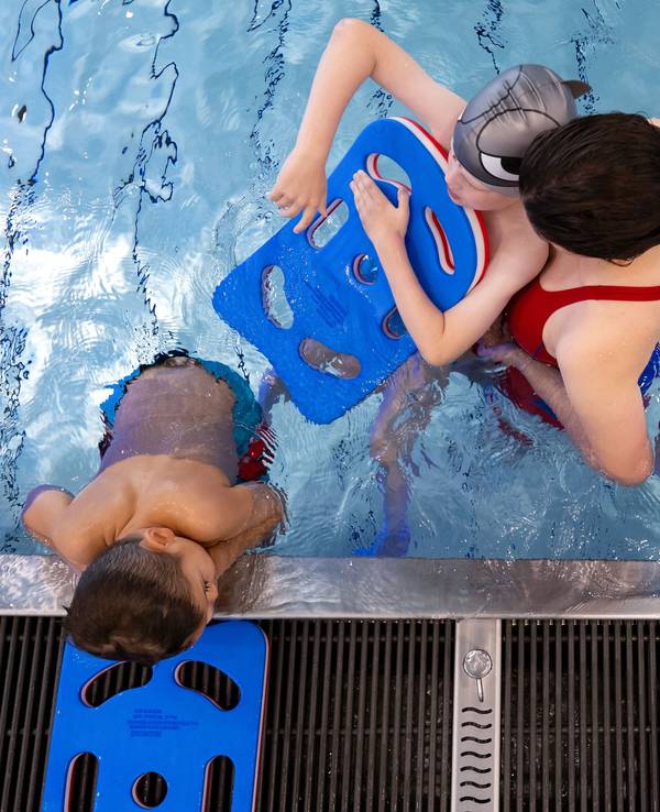 Kinder nehmen an einem Schwimmkurs teil.