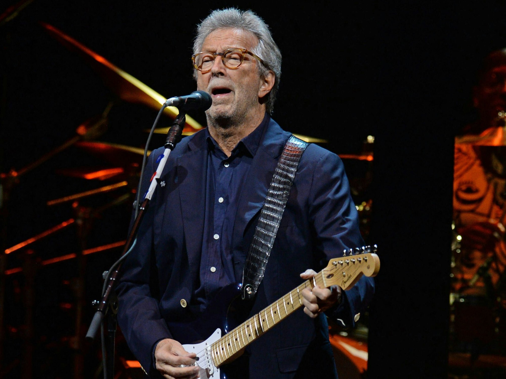 Eric Clapton steht beim Konzert auf der Bühne.