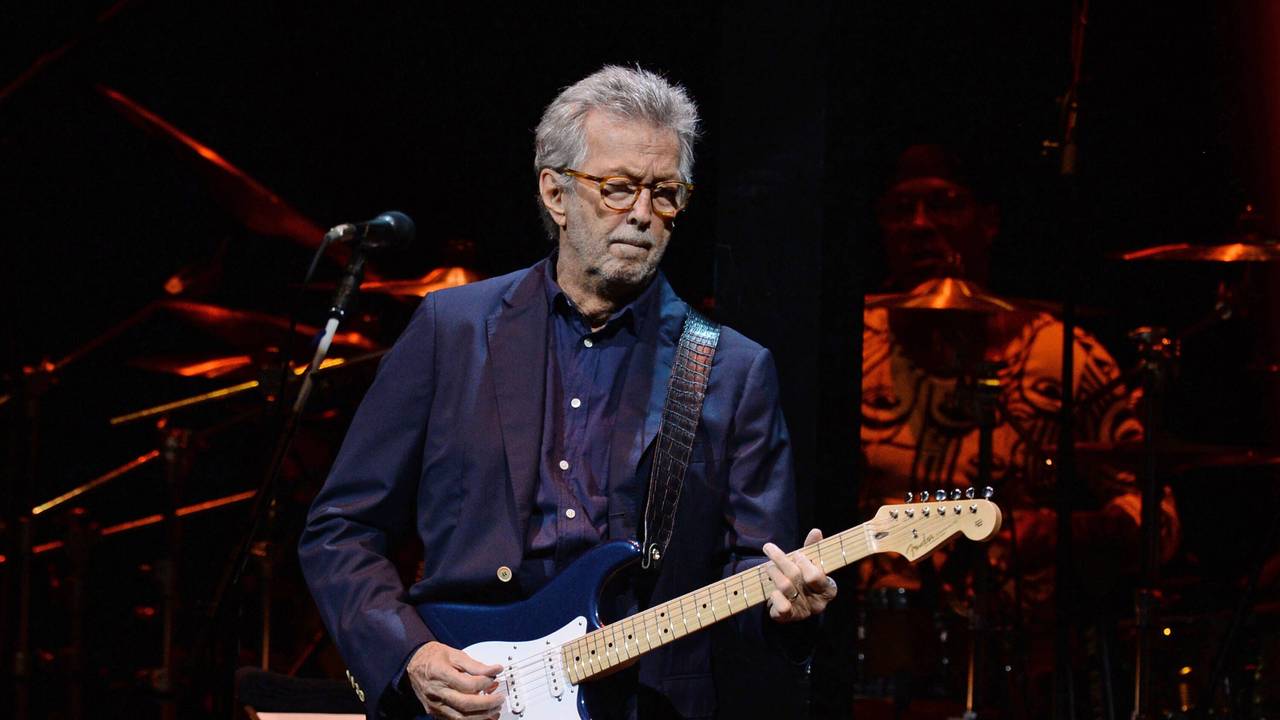 Eric Clapton steht bei einem Konzert auf der Bühne.