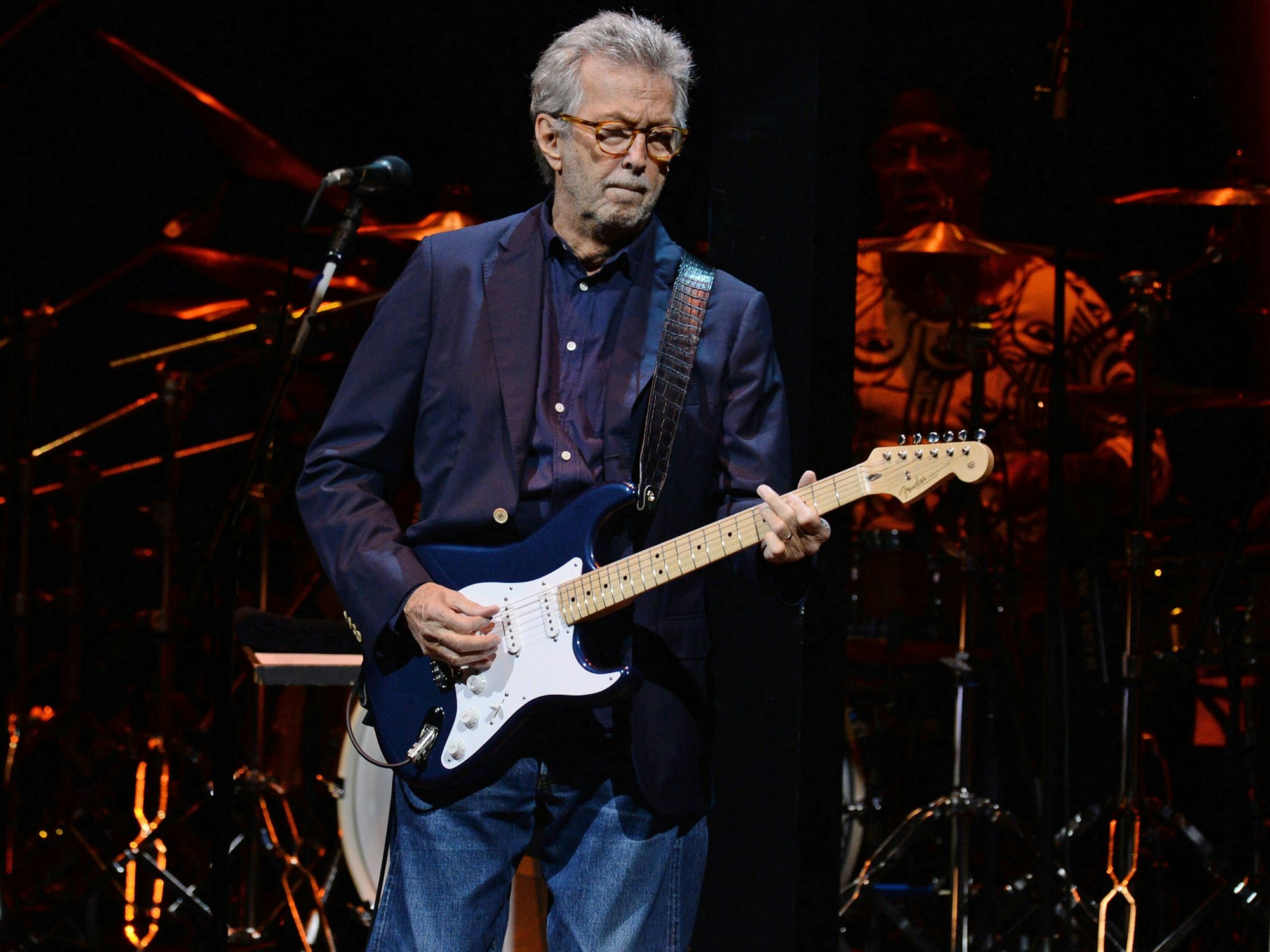 Eric Clapton steht bei einem Konzert auf der Bühne.