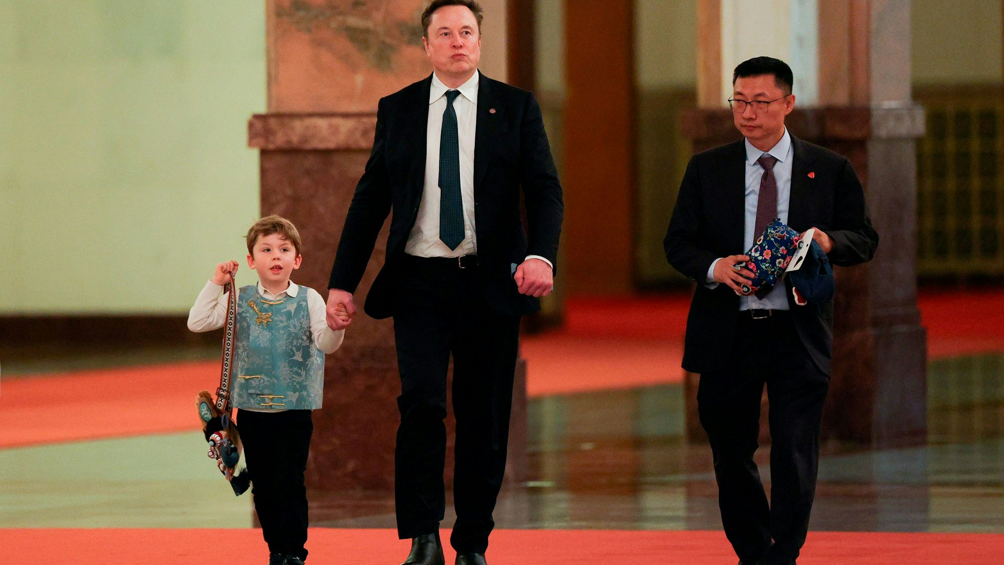 Elon Musk, sein Sohn und ein Mann weitergehen