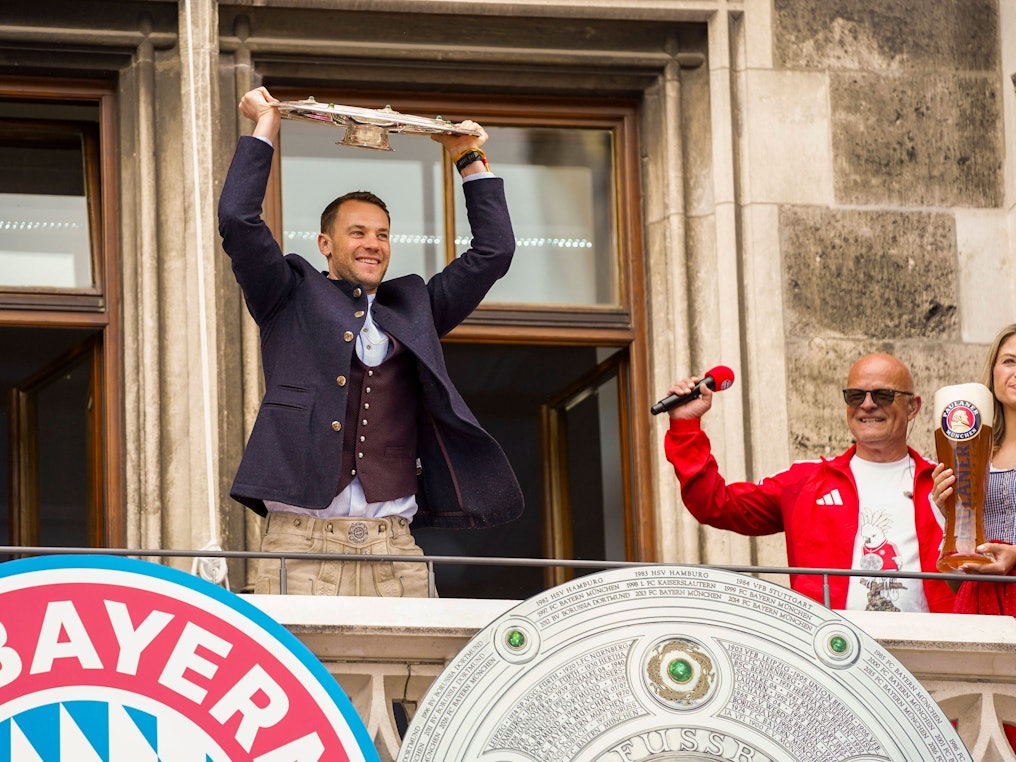 Torwart Manuel Neuer feiert auf dem Rathausbalkon in München mit der Meisterschale.