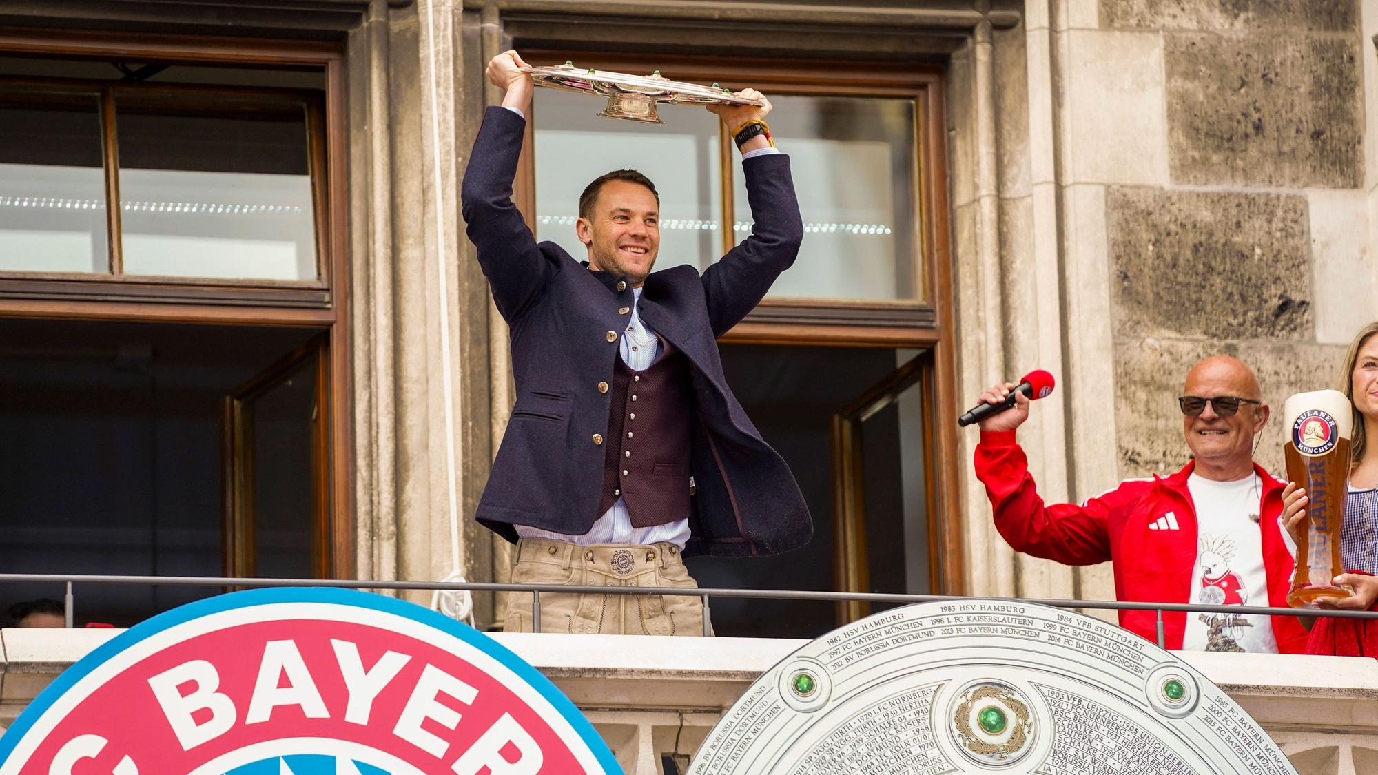Torwart Manuel Neuer feiert auf dem Rathausbalkon in München mit der Meisterschale.